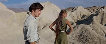 Movie still from “Zabriskie Point” (1970), directed by Michelangelo Antonioni – A man and a woman standing on a hill side; Medium shot, Low angle