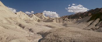 Movie still from “Zabriskie Point” (1970), directed by Michelangelo Antonioni – A person standing in the middle of a desert; Extreme Wide shot, High angle