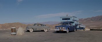 Movie still from “Zabriskie Point” (1970), directed by Michelangelo Antonioni – An old car is parked in front of an old truck; Wide shot, Low angle