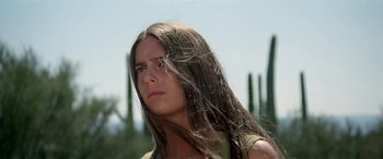 Movie still from “Zabriskie Point” (1970), directed by Michelangelo Antonioni – A woman with long brown hair standing in a field; Close Up shot, Low angle