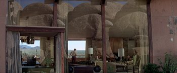 Movie still from “Zabriskie Point” (1970), directed by Michelangelo Antonioni – A man standing in front of a window in a living room; Extreme Wide shot, Low angle