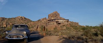 Movie still from “Zabriskie Point” (1970), directed by Michelangelo Antonioni – A person standing in front of a building on a hill; Extreme Wide shot, Low angle