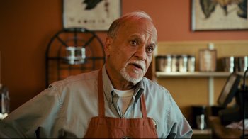 Movie still from “Zack and Miri Make a Porno” (2008), directed by Kevin Smith – An older man wearing an apron in a kitchen; Close Up shot, Over the shoulder angle