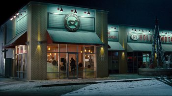 Movie still from “Zack and Miri Make a Porno” (2008), directed by Kevin Smith – A person standing in front of a restaurant at night; Extreme Wide shot, High angle