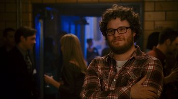 Movie still from “Zack and Miri Make a Porno” (2008), directed by Kevin Smith – A man with a beard and glasses is posing for a picture; Medium shot, Over the shoulder angle