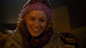 Movie still from “Zack and Miri Make a Porno” (2008), directed by Kevin Smith – A woman wearing a hat and a scarf smiling for the camera; Close Up shot, Over the shoulder angle