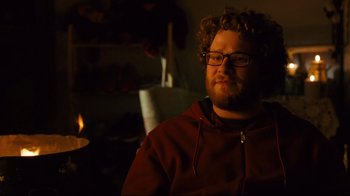 Movie still from “Zack and Miri Make a Porno” (2008), directed by Kevin Smith – A man with a beard and glasses is sitting in a dark room; Close Up shot, Over the shoulder angle
