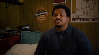 Movie still from “Zack and Miri Make a Porno” (2008), directed by Kevin Smith – A man sitting on a couch in a living room; Medium shot, Over the shoulder angle