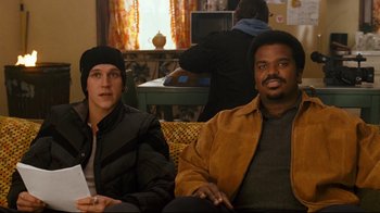Movie still from “Zack and Miri Make a Porno” (2008), directed by Kevin Smith – A man and a woman are sitting on a couch; Medium shot, High angle
