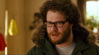 Movie still from “Zack and Miri Make a Porno” (2008), directed by Kevin Smith – A man with a beard wearing glasses and a jacket; Close Up shot, Over the shoulder angle