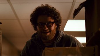 Movie still from “Zack and Miri Make a Porno” (2008), directed by Kevin Smith – A man with curly hair and glasses smiling for the camera; Close Up shot, Low angle