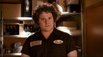 Movie still from “Zack and Miri Make a Porno” (2008), directed by Kevin Smith – A man with curly brown hair wearing a black shirt; Close Up shot, Over the shoulder angle