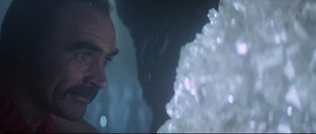 Movie still from “Zardoz” (1974), directed by John Boorman – A person looking at something in the water; Close Up shot, Over the shoulder angle