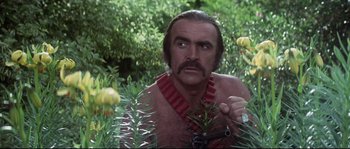 Movie still from “Zardoz” (1974), directed by John Boorman – A man with a beard and a necklace in a forest; Close Up shot, Low angle