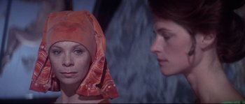Movie still from “Zardoz” (1974), directed by John Boorman – A woman wearing a headscarf looking at another woman; Close Up shot, Over the shoulder angle