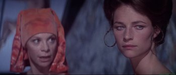 Movie still from “Zardoz” (1974), directed by John Boorman – A woman in a red head covering and a woman in a white head covering; Close Up shot, Over the shoulder angle
