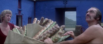 Movie still from “Zardoz” (1974), directed by John Boorman – A basket full of bread sitting on top of a table; Medium shot, Low angle