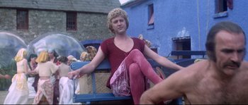 Movie still from “Zardoz” (1974), directed by John Boorman – A woman sitting on a bed with a basket of kittens; Medium shot, Low angle