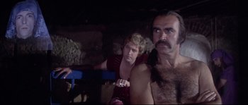 Movie still from “Zardoz” (1974), directed by John Boorman – A man and a woman are sitting in a cave; Medium shot, Over the shoulder angle