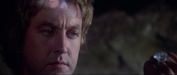 Movie still from “Zardoz” (1974), directed by John Boorman – A man's face in the dark; Close Up shot, Over the shoulder angle