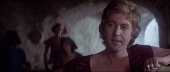 Movie still from “Zardoz” (1974), directed by John Boorman – A person wearing a red shirt; Close Up shot, Over the shoulder angle