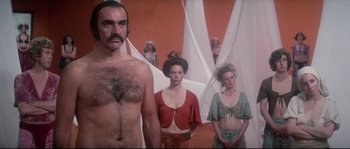 Movie still from “Zardoz” (1974), directed by John Boorman – A group of people standing next to each other in a room; Medium shot, Low angle