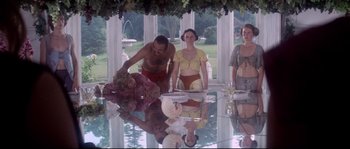 Movie still from “Zardoz” (1974), directed by John Boorman – A group of people standing around a glass table; Wide shot, Low angle
