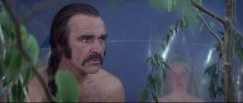 Movie still from “Zardoz” (1974), directed by John Boorman – A man with a mustache is looking into a mirror; Close Up shot, Low angle