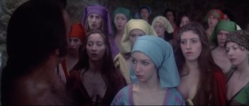 Movie still from “Zardoz” (1974), directed by John Boorman – A group of women wearing colorful headscarves and looking at the camera; Medium shot, High angle