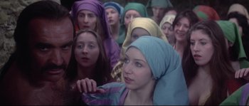 Movie still from “Zardoz” (1974), directed by John Boorman – A group of people wearing head scarfs in a room; Close Up shot, High angle