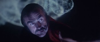 Movie still from “Zardoz” (1974), directed by John Boorman – A person looking at a projector screen; Close Up shot, Over the shoulder angle