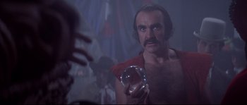 Movie still from “Zardoz” (1974), directed by John Boorman – A man holding a crystal ball; Close Up shot, Low angle