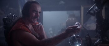 Movie still from “Zardoz” (1974), directed by John Boorman – A man with a beard holding a toothbrush in his mouth; Close Up shot, Low angle
