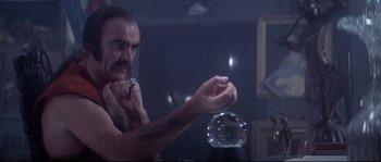 Movie still from “Zardoz” (1974), directed by John Boorman – A man is brushing his teeth in front of a crystal ball; Medium shot, Low angle