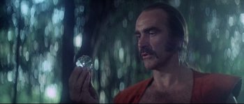 Movie still from “Zardoz” (1974), directed by John Boorman – A man holding a diamond in his hand; Close Up shot, Low angle