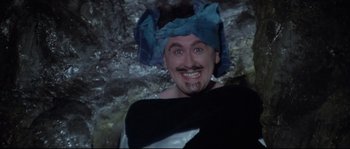 Movie still from “Zardoz” (1974), directed by John Boorman – A man with a beard and mustache wearing a blue hat; Close Up shot, High angle