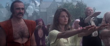 Movie still from “Zardoz” (1974), directed by John Boorman – A group of people standing in a field; Medium shot, Over the shoulder angle