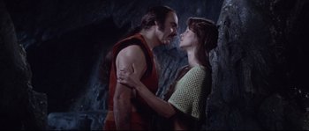 Movie still from “Zardoz” (1974), directed by John Boorman – A man and a woman are standing in front of a cave; Medium shot, Low angle