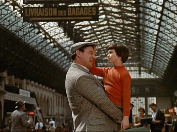 Movie still from “Zazie dans le Métro” (1960), directed by Louis Malle – A man and a boy are standing in a train station; Medium shot, High angle
