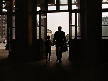 Movie still from “Zazie dans le Métro” (1960), directed by Louis Malle – A man and a little girl are standing in front of an open door; Wide shot, Low angle