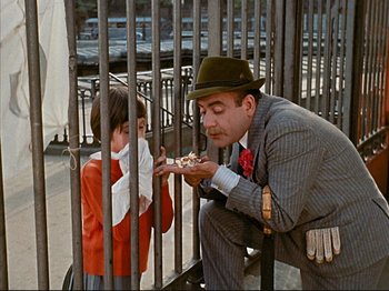 Movie still from “Zazie dans le Métro” (1960), directed by Louis Malle – A man and a little girl eating a piece of pizza; Medium shot, Low angle