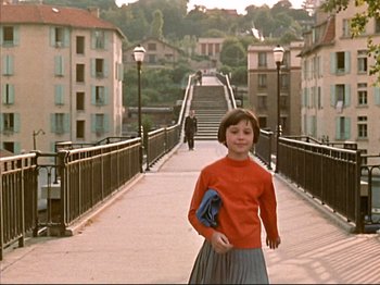 Movie still from “Zazie dans le Métro” (1960), directed by Louis Malle – A young girl is walking across a bridge; Wide shot, High angle