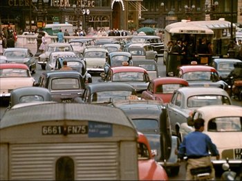 Movie still from “Zazie dans le Métro” (1960), directed by Louis Malle – A bunch of cars that are in the street; Extreme Wide shot, High angle