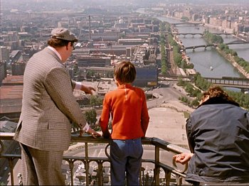 Movie still from “Zazie dans le Métro” (1960), directed by Louis Malle – A man and two boys looking over a city; Wide shot, High angle