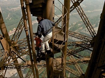 Movie still from “Zazie dans le Métro” (1960), directed by Louis Malle – A man standing on top of a metal structure; Wide shot, High angle