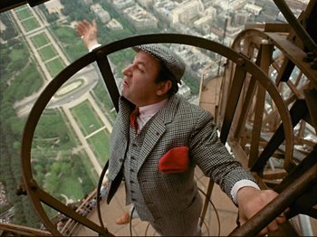 Movie still from “Zazie dans le Métro” (1960), directed by Louis Malle – A man standing on top of a metal structure; Medium shot, Overhead angle