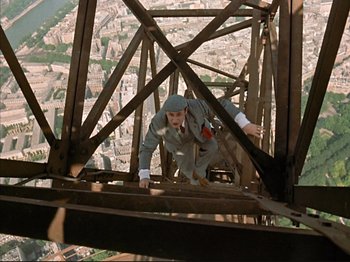Movie still from “Zazie dans le Métro” (1960), directed by Louis Malle – A man is climbing up the side of a building; Wide shot, Overhead angle