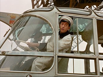 Movie still from “Zazie dans le Métro” (1960), directed by Louis Malle – A man driving a bus in a white uniform; Medium shot, Low angle