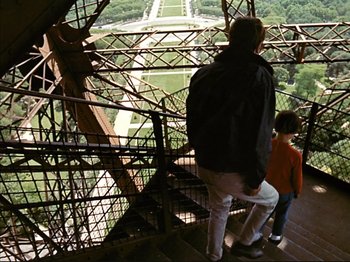 Movie still from “Zazie dans le Métro” (1960), directed by Louis Malle – A man and a child look down from the top of the eiffel tower; Wide shot, Low angle