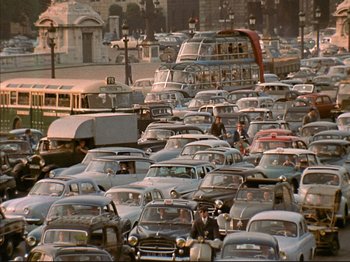 Movie still from “Zazie dans le Métro” (1960), directed by Louis Malle – A bunch of cars are parked on the street; Extreme Wide shot, High angle